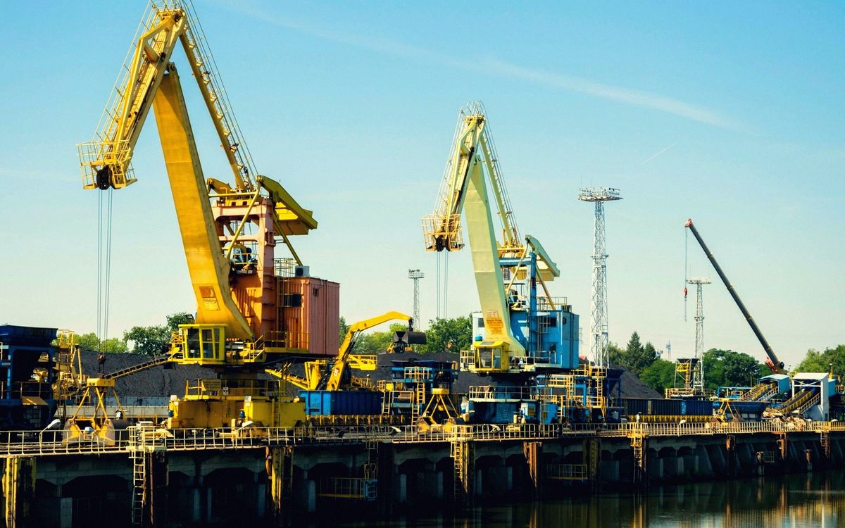 Yellow port cranes loading on the river