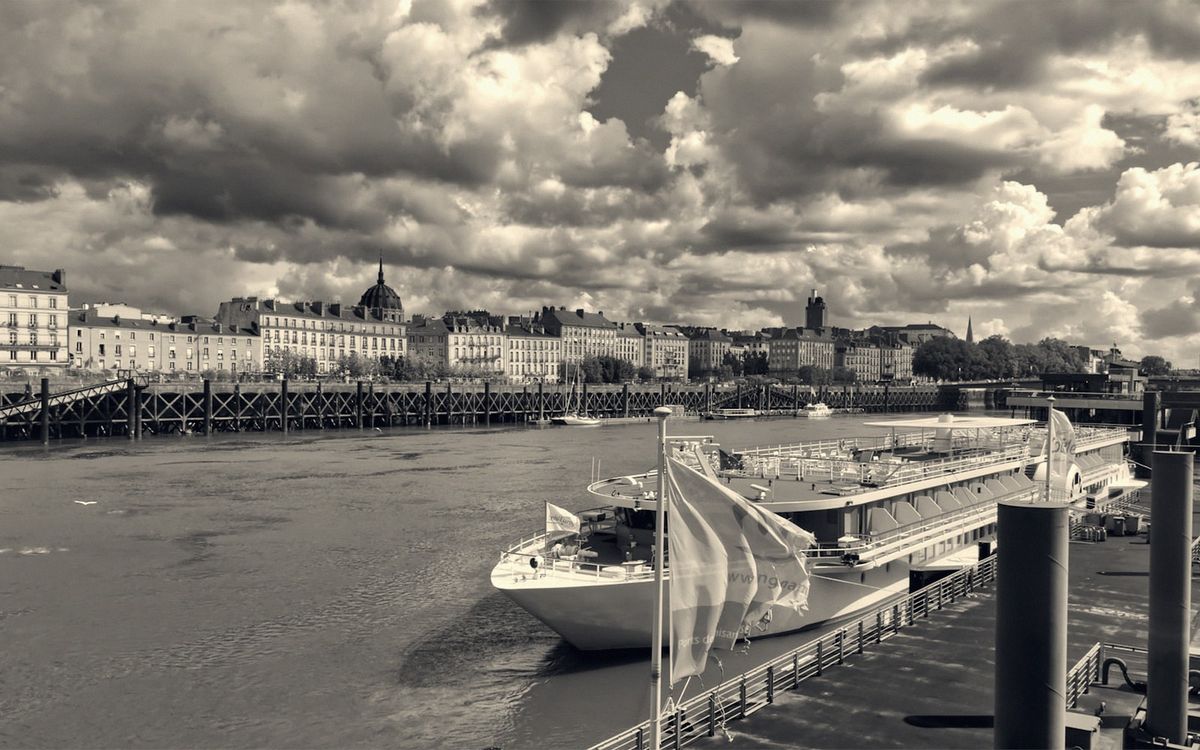 A river cruiser moored on the Loire quays, the dome of Notre-Dame-de-Bon-Port beyond